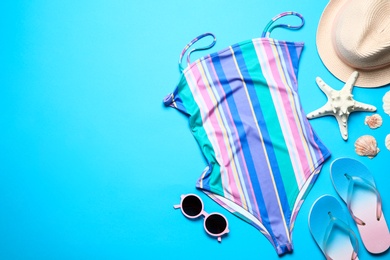 Photo of Flat lay composition with one-piece swimsuit and beach objects on color background