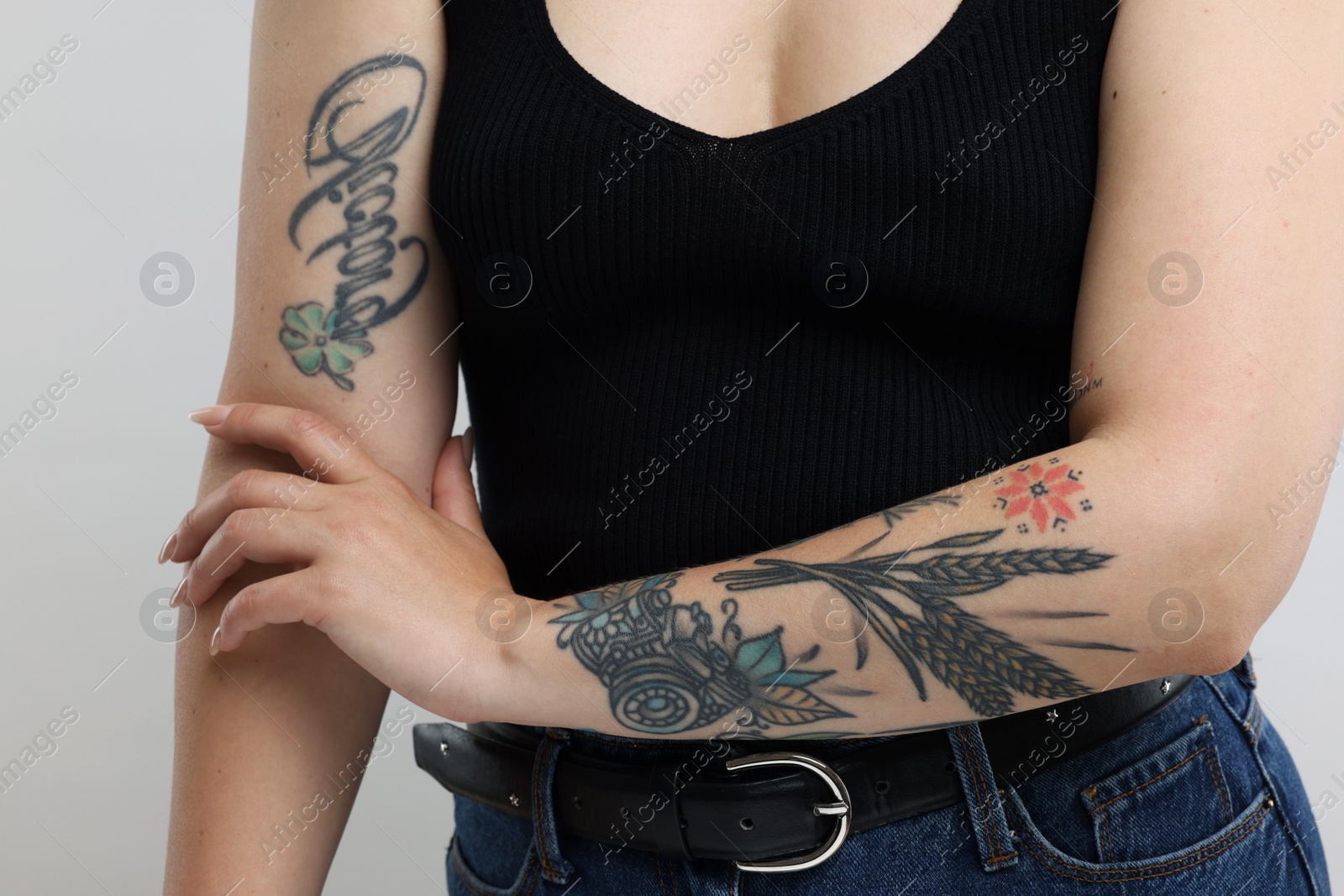 Photo of Woman with cool tattoos on gray background, closeup