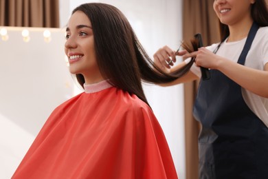 Stylist cutting hair of client in professional salon