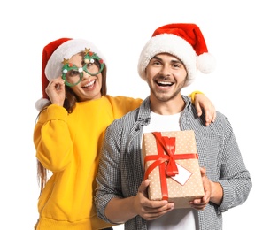 Young couple with Christmas gift on white background