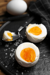 Photo of Tasty boiled chicken eggs on slate plate, closeup