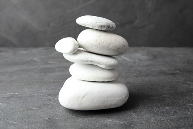 Stack of zen stones on table against grey background