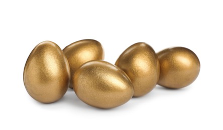 Photo of Many shiny golden eggs on white background