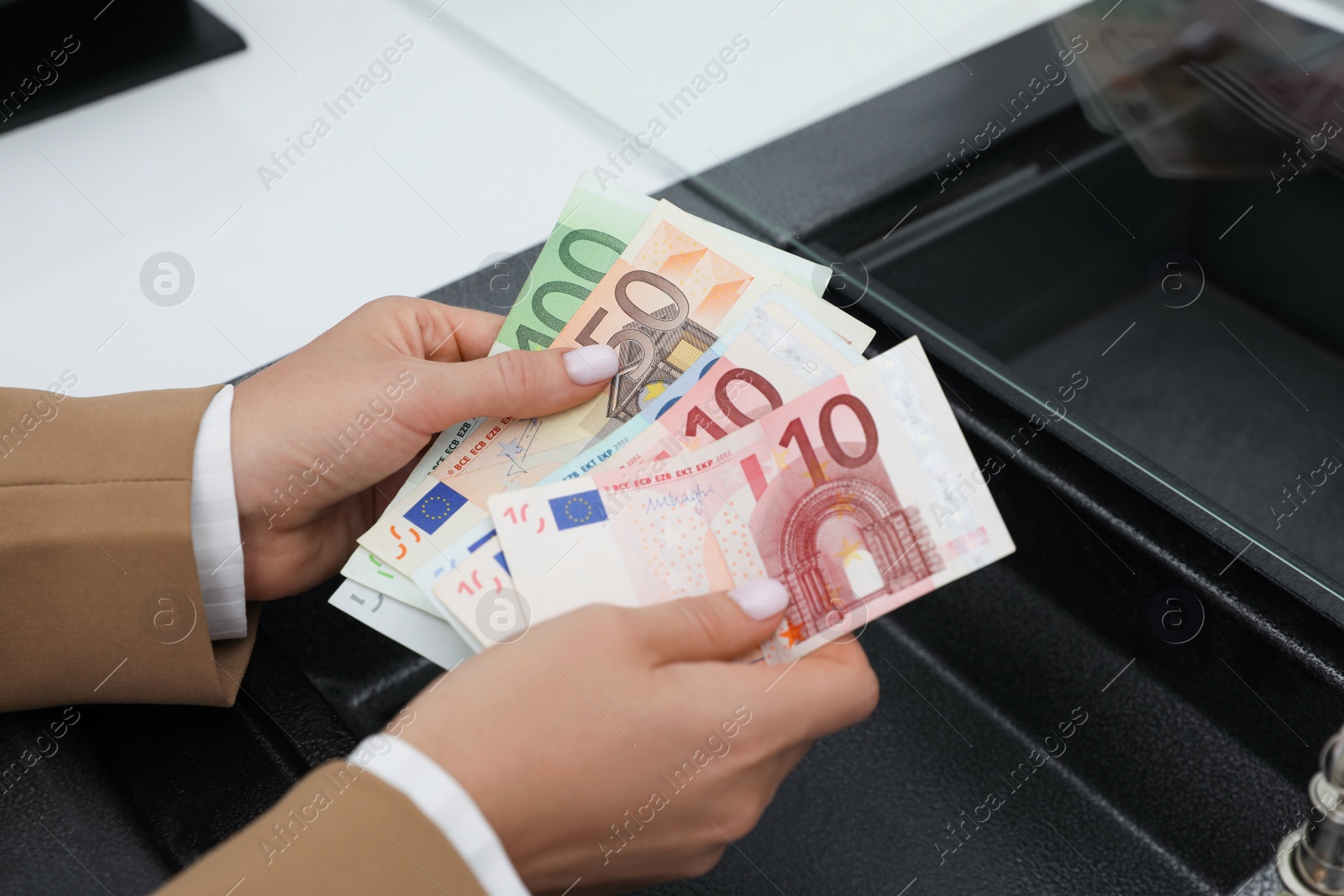 Photo of Woman with money at cash department window, closeup. Currency exchange