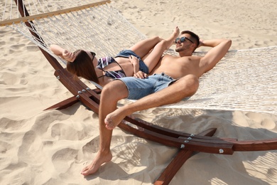 Photo of Young lovely relaxing in hammock on beach