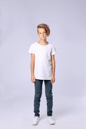 Photo of Cute little boy in casual outfit on light background