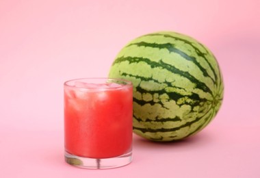 Photo of Glass of delicious drink and fresh watermelon on pink background