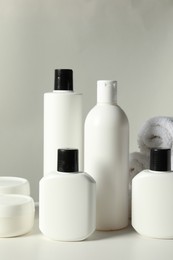 Photo of Different bath accessories on white table against grey background, closeup