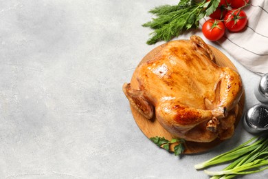 Photo of Tasty roasted chicken with different products on light grey table, flat lay. Space for text
