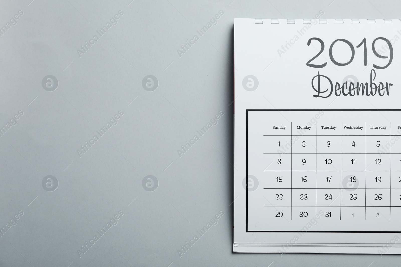 Photo of December 2019 calendar on light grey background, top view. Space for text