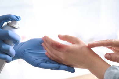 Photo of Applying burn spray onto injured skin, closeup