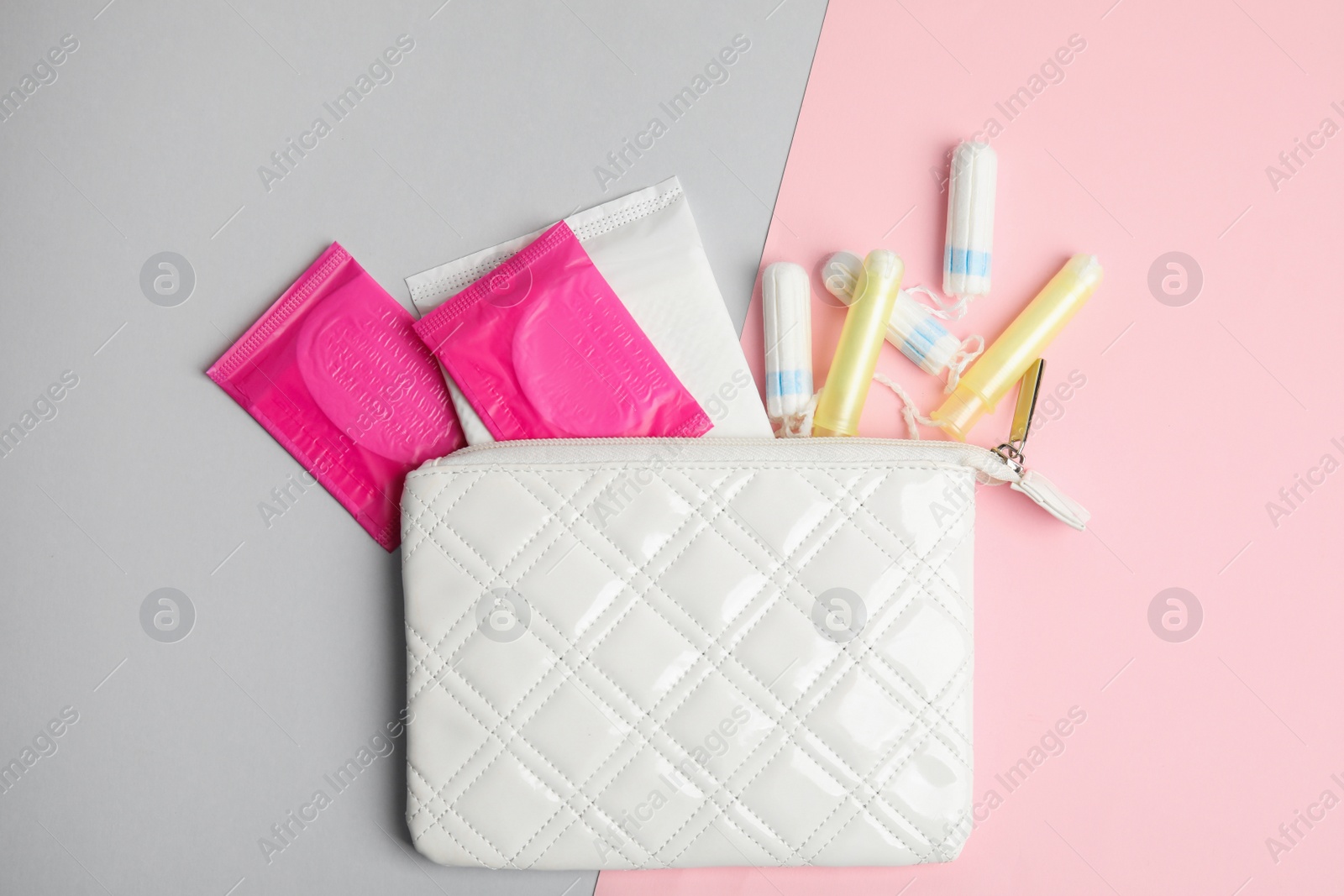 Photo of Tampons, pads and bag on color background, flat lay