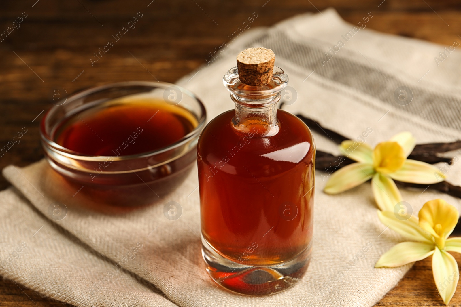 Photo of Aromatic homemade vanilla extract on wooden table