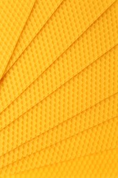 Natural beeswax sheets as background, top view