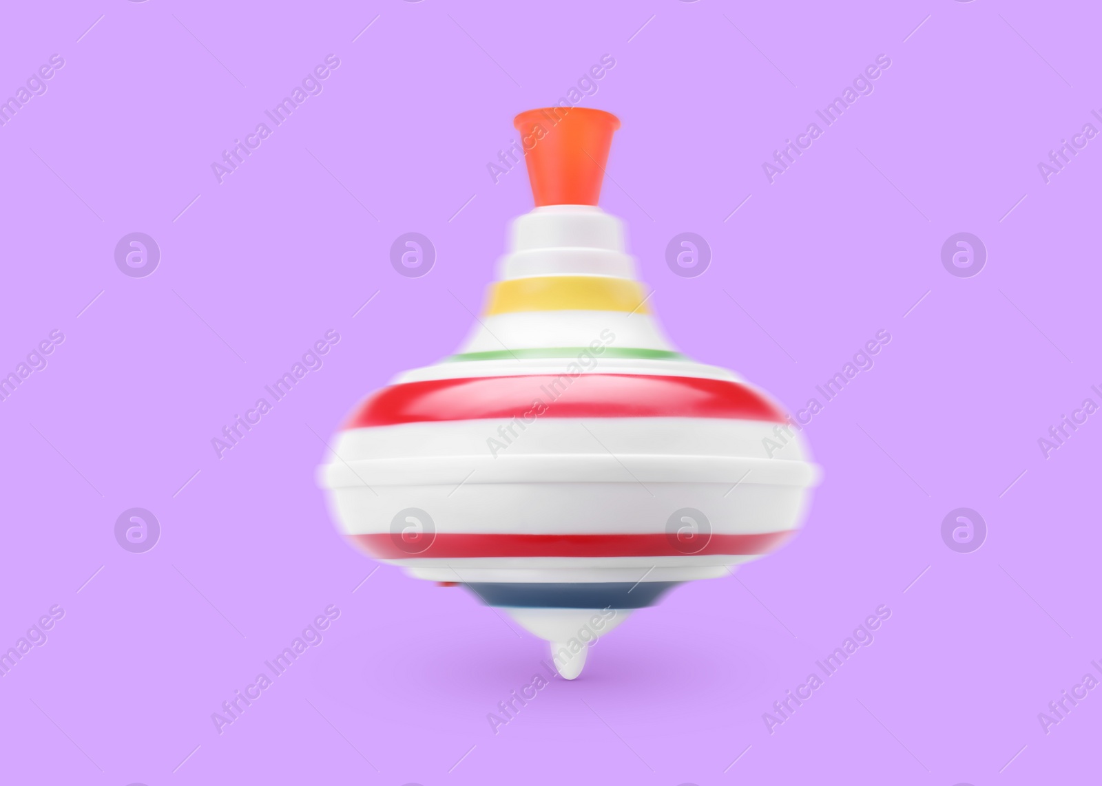 Image of One spinning top in motion on violet background. Toy whirligig