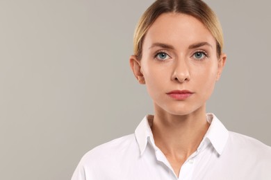 Portrait of beautiful woman on light grey background, space for text