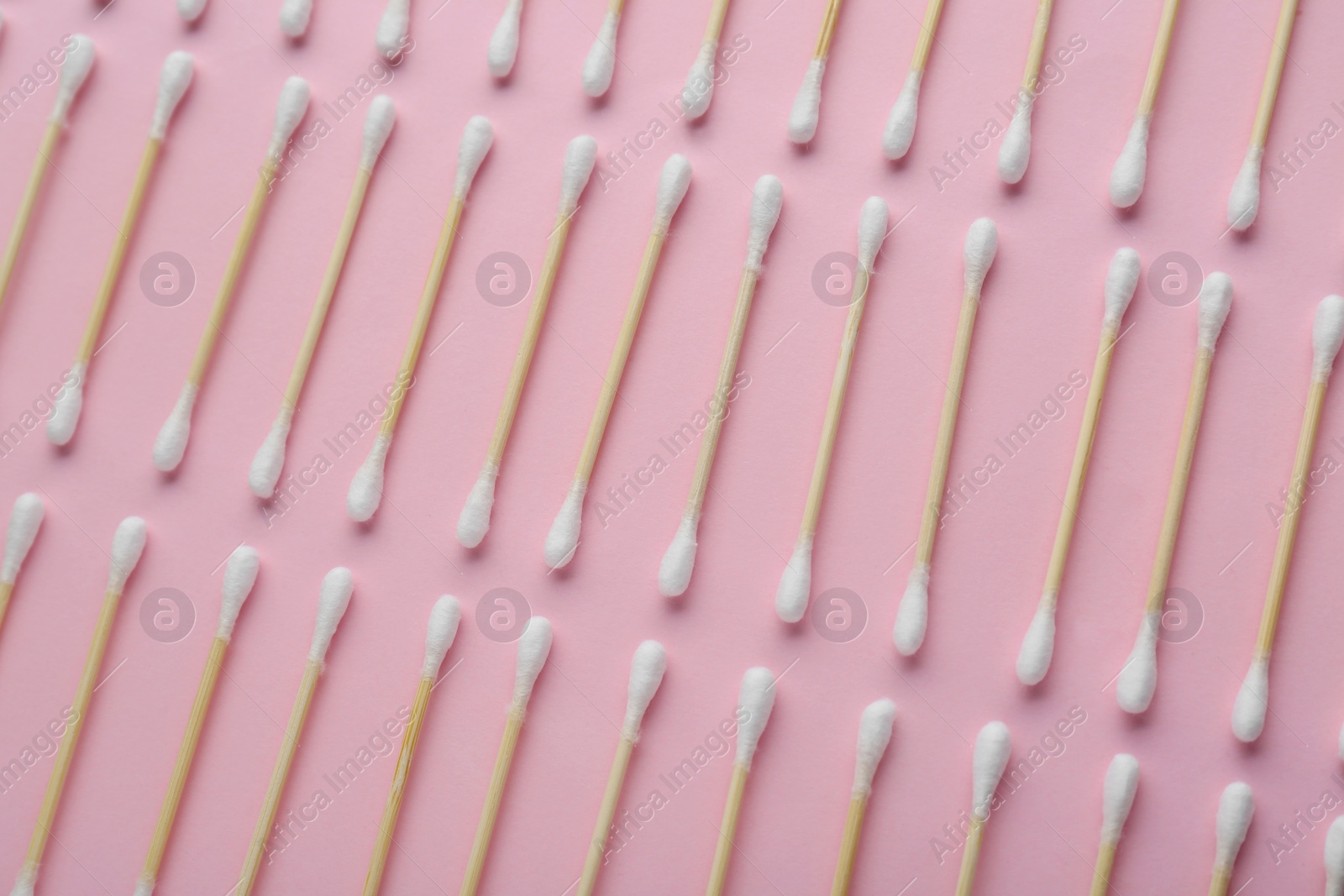 Photo of Many wooden cotton buds on pink background, flat lay