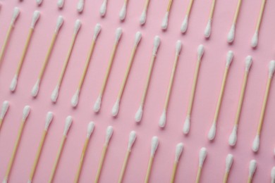 Photo of Many wooden cotton buds on pink background, flat lay