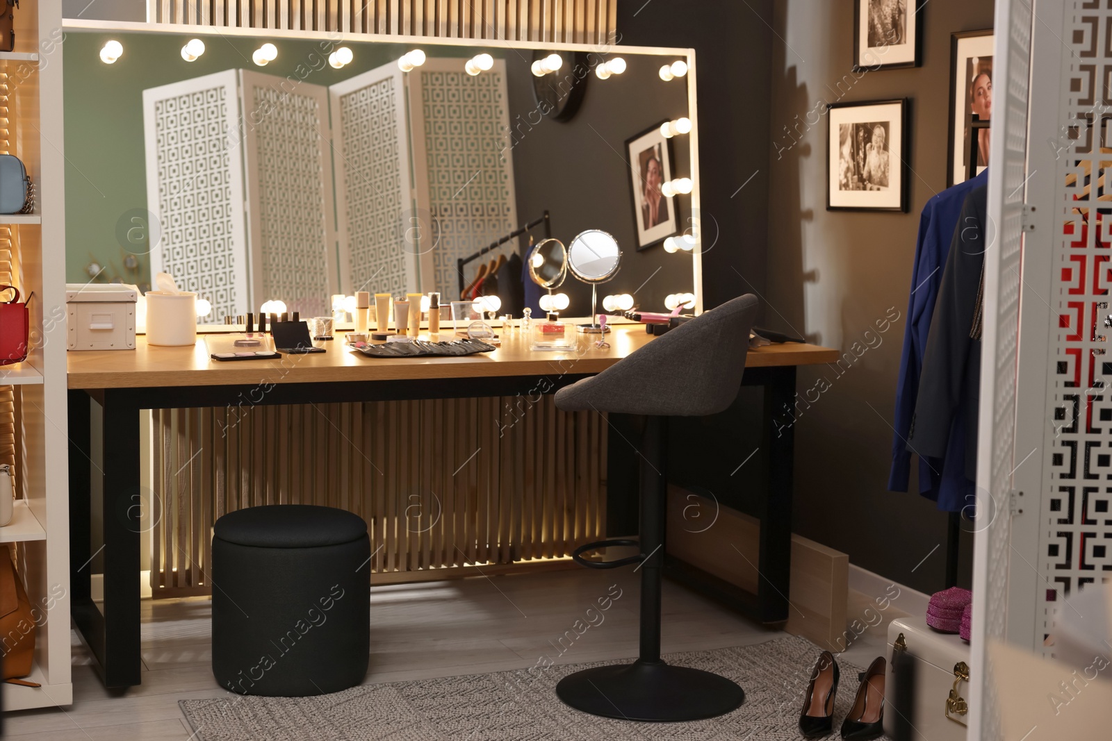 Photo of Makeup room. Stylish mirror on dressing table with different beauty products