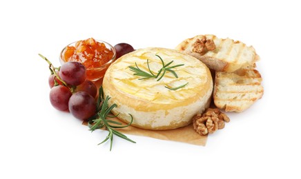 Tasty baked brie cheese with grapes, walnuts, bread and jam isolated on white