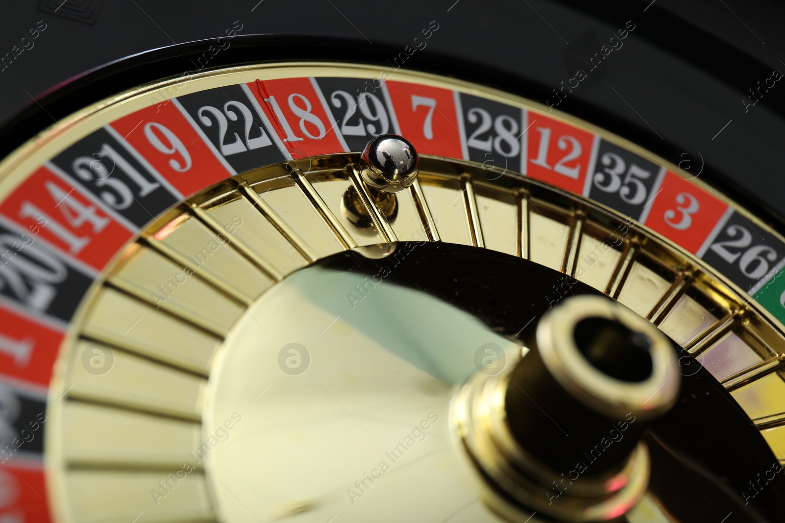 Photo of Roulette wheel with ball, closeup. Casino game