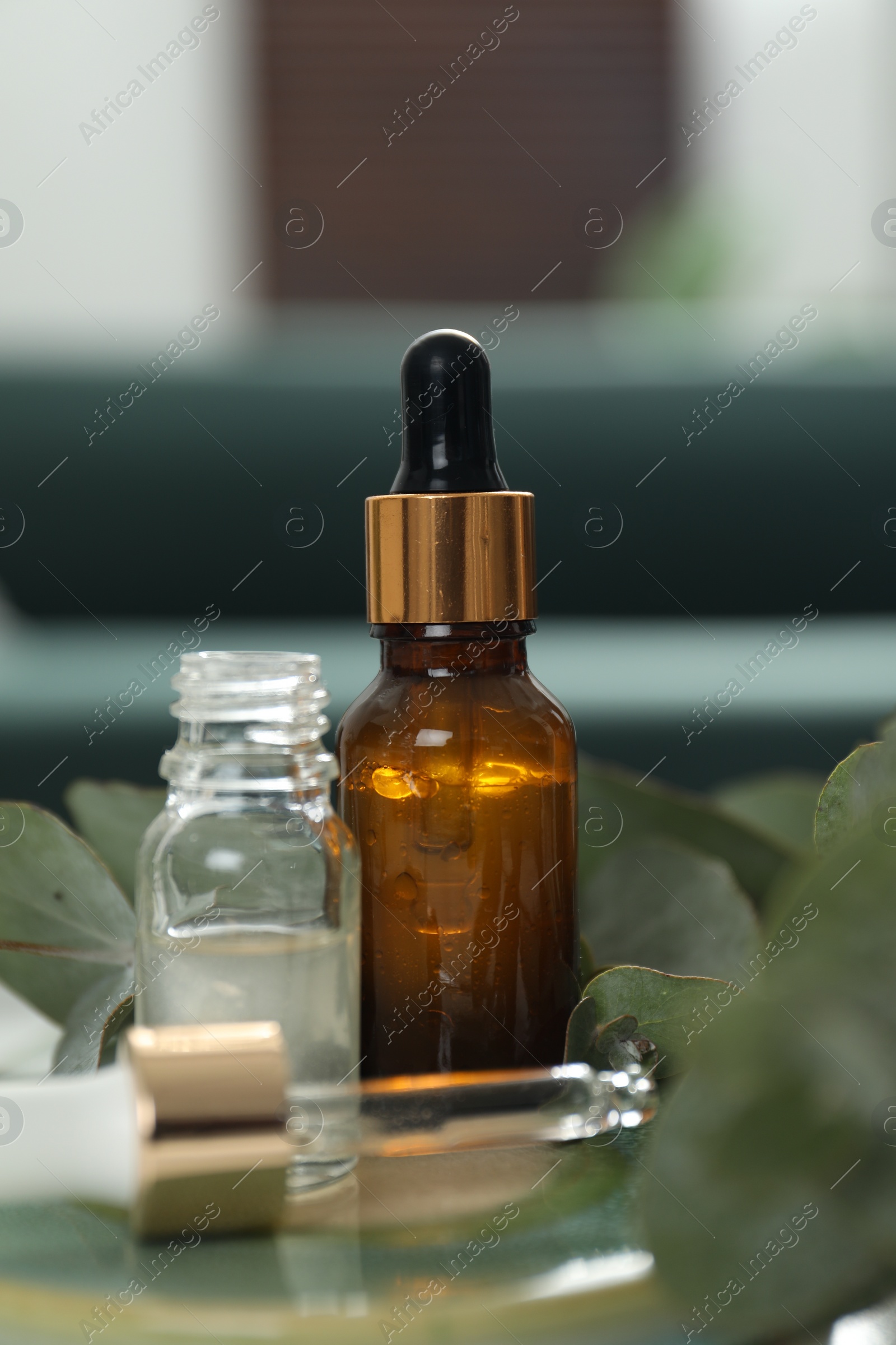 Photo of Aromatherapy. Bottles of essential oil and eucalyptus leaves on table