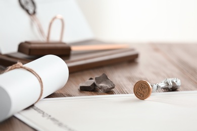 Photo of Vintage notary stamp and documents on wooden table, closeup. Space for text