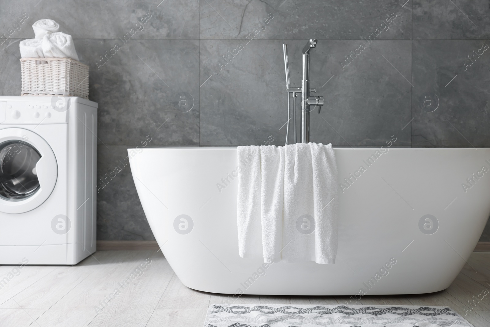 Photo of Fresh white towels on tub in bathroom