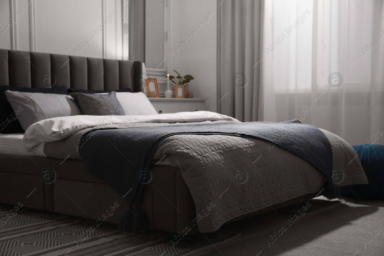 Photo of Comfortable bed with pillows and bedding in stylish room. Interior design