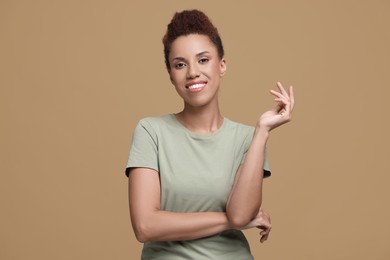 Photo of Portrait of beautiful young woman on light brown background