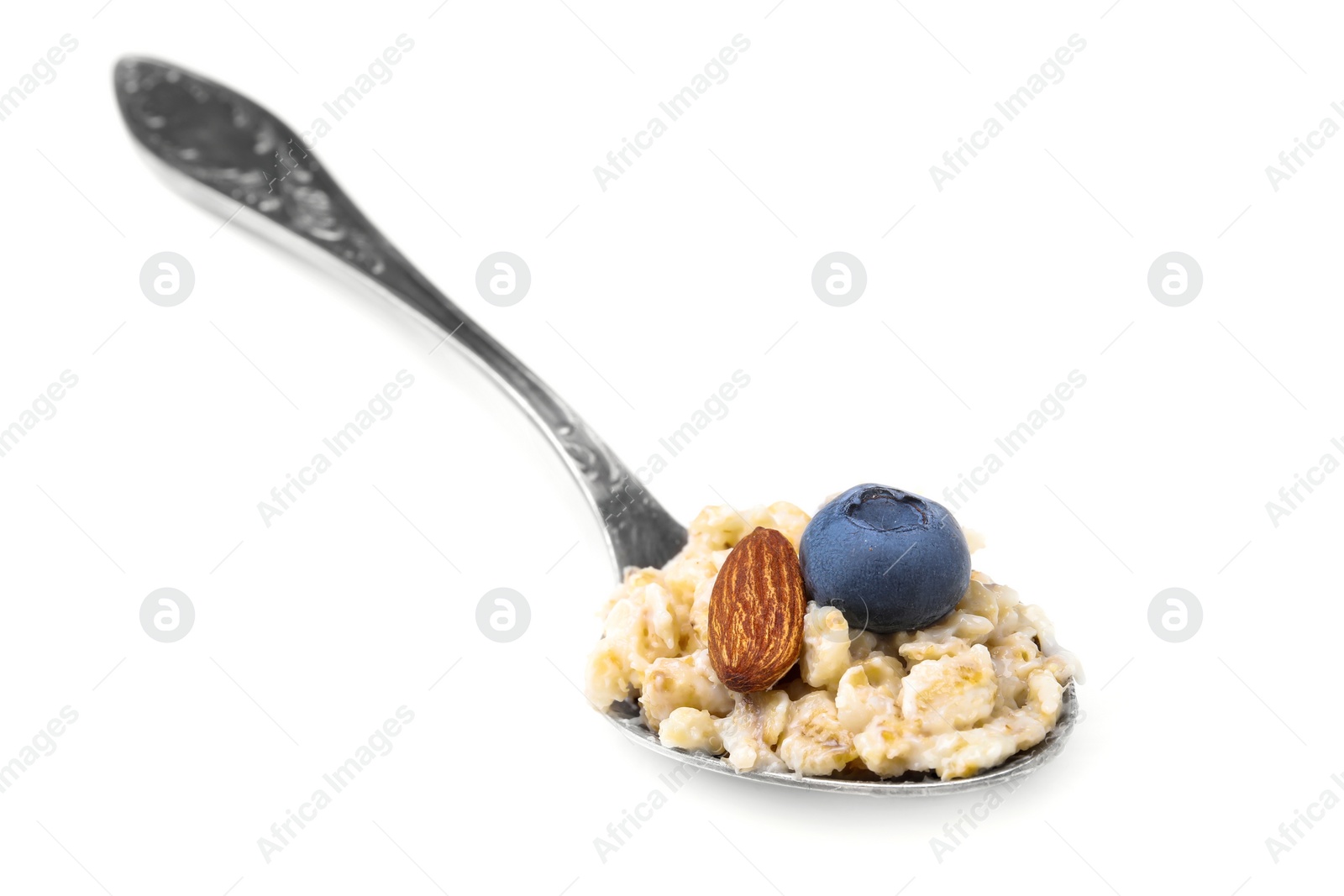 Photo of Spoon with oatmeal, blueberry and almond isolated on white