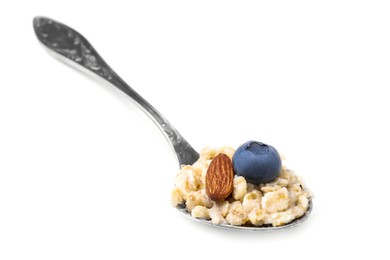 Photo of Spoon with oatmeal, blueberry and almond isolated on white