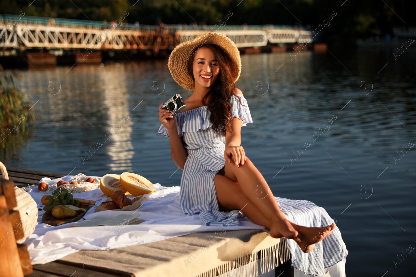 Photo of Young woman spending time on pier at picnic