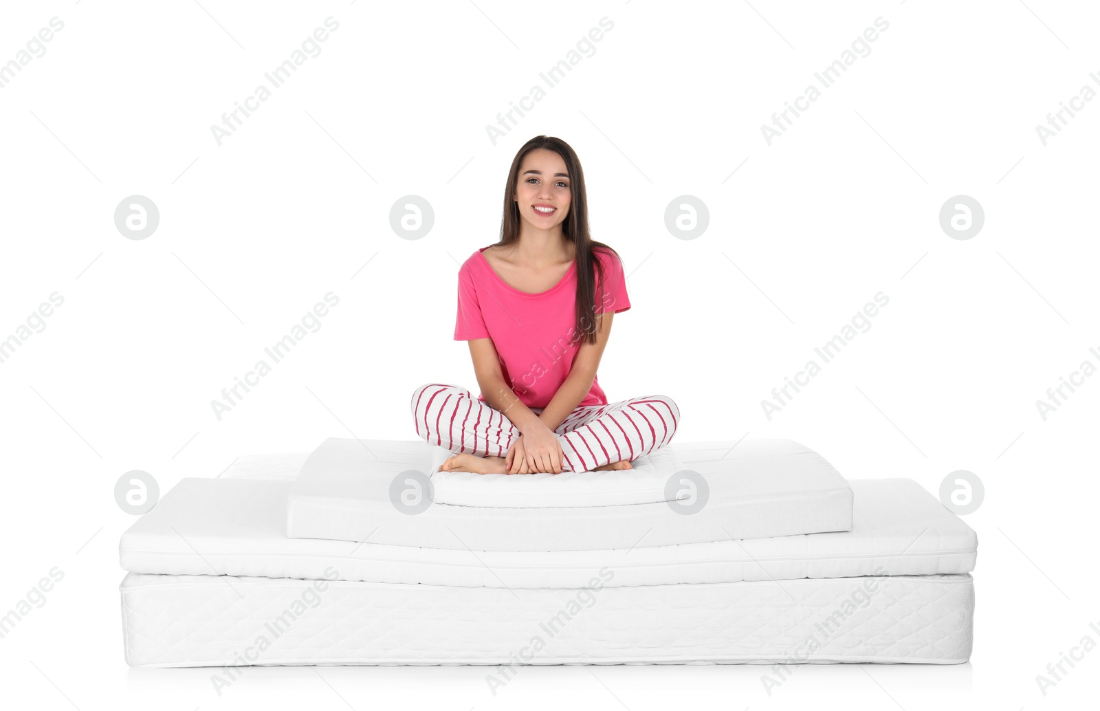 Photo of Young woman sitting on mattress pile against white background