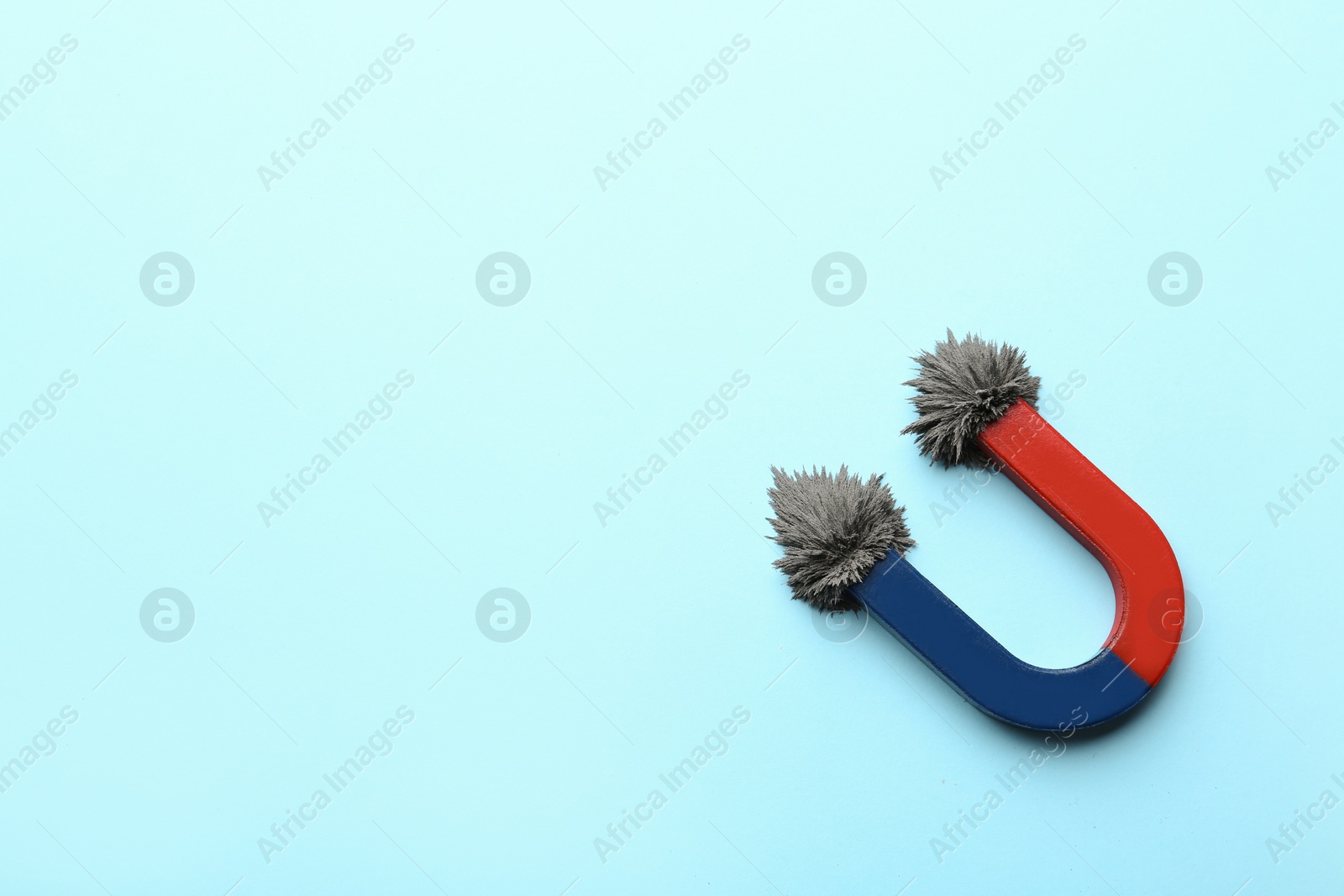 Photo of Magnet with iron powder on color background, top view. Space for text
