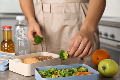 Woman preparing food for her child at table in kitchen, closeup. Healthy school lunch