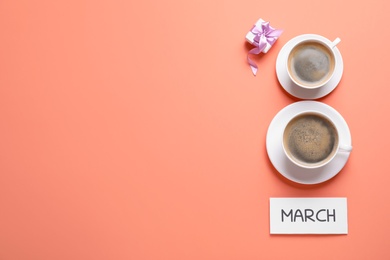 Photo of 8 March greeting card design with cups of coffee, gift box and space for text on coral background, flat lay. International Women's day