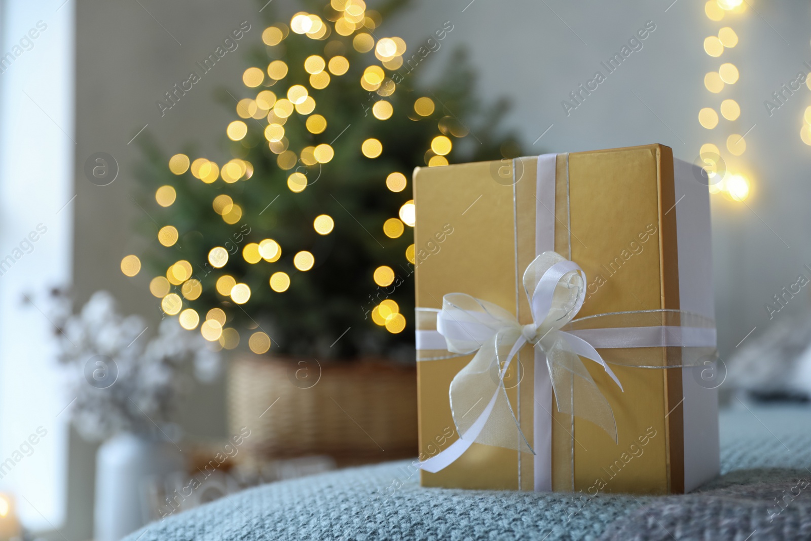 Photo of Christmas gift box on bed in festive interior