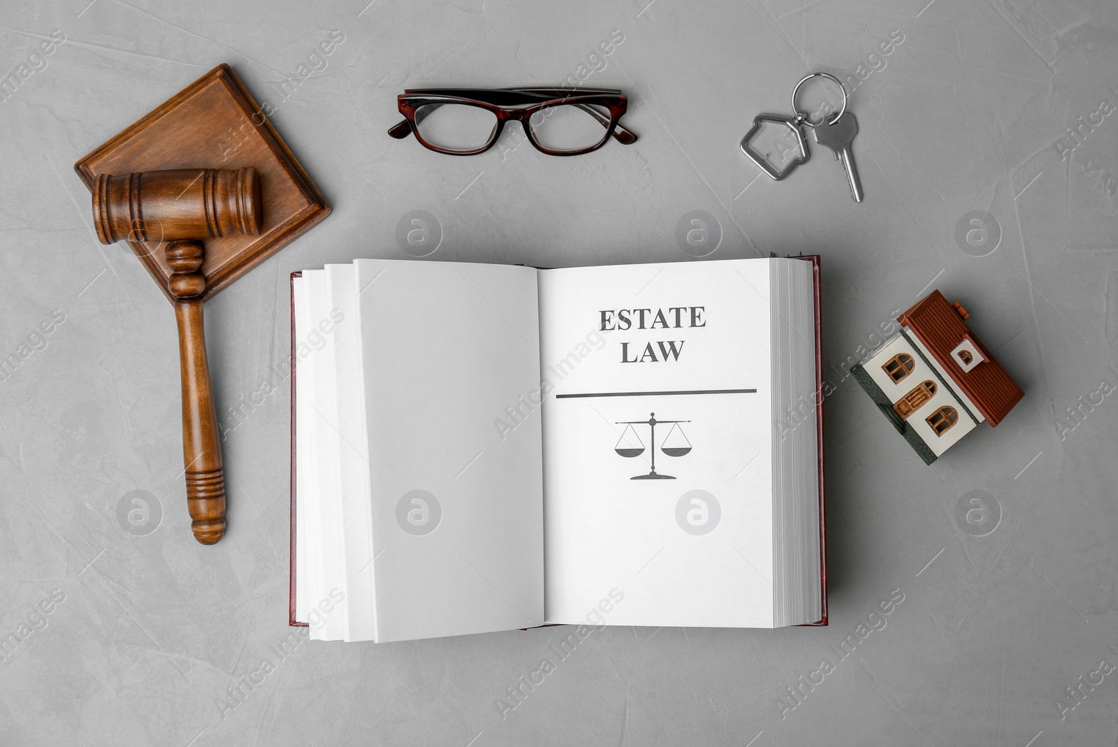 Photo of Flat lay composition with book, gavel and house model on grey background. Estate law concept