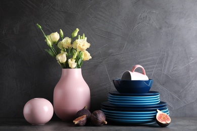 Photo of Composition with dinnerware on table against grey background. Interior element
