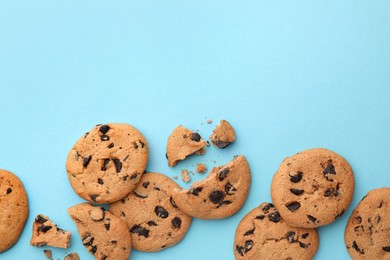 Photo of Many delicious chocolate chip cookies on light blue background, flat lay. Space for text