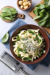 Delicious pasta with green peas and ingredients on grey table, flat lay