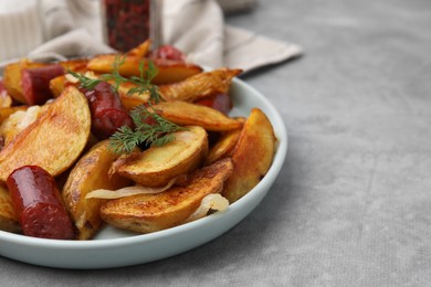 Photo of Delicious baked potato with thin dry smoked sausages, onion and dill on gray table, closeup. Space for text