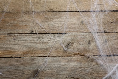 Photo of Creepy white cobweb hanging on wooden wall