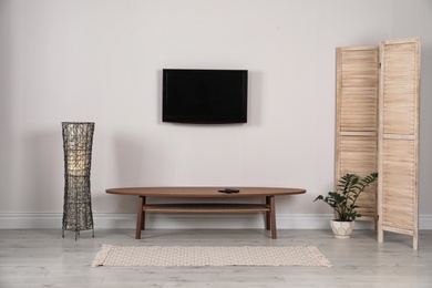 Photo of Modern TV set mounted on wall in living room