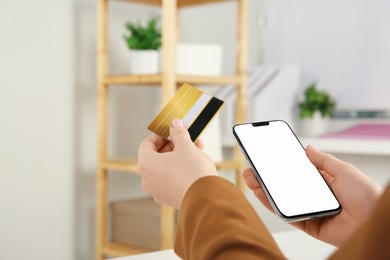 Photo of Online payment. Woman using credit card and smartphone with blank screen indoors, closeup. Space for text