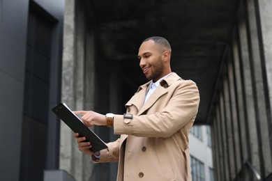 Photo of Happy man with clipboard outdoors. Lawyer, businessman, accountant or manager