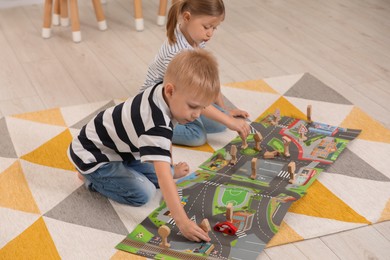 Little children playing with set of wooden road signs and toy cars indoors