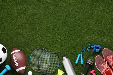 Photo of Different sport tools on green grass, flat lay. Space for text