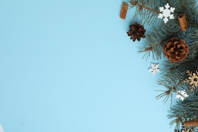 Winter composition with fir tree on light blue background, flat lay. Space for text